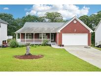 Charming brick home with a well-manicured lawn and a covered front porch at 528 Savannah Rose Way, Lawrenceville, GA 30045