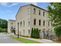 Beautifully detailed brick townhome with manicured lawn, shrubbery, and mature shade trees at 302 Boxwood Ln, Roswell, GA 30075
