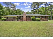 Charming brick home featuring a classic design and a lush, green front yard at 3630 Spot Rd, Cumming, GA 30040