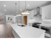 Bright kitchen boasts a large island with quartz countertops and stainless steel appliances at 5448 Howington E Ct # 194, Buford, GA 30518