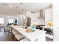 Bright, open kitchen featuring a large island, stainless steel appliances, and modern pendant lighting at 5448 Howington E Ct # 194, Buford, GA 30518