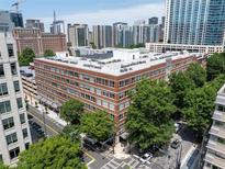 Brick condo building exterior with cityscape views and mature trees near city streets and high rise buildings at 800 Peachtree Ne St # 8531, Atlanta, GA 30308
