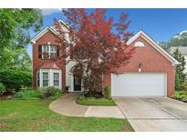 Charming two-story brick home featuring manicured lawn, two-car garage, and mature landscaping at 1100 Carrington Pkwy, Villa Rica, GA 30180