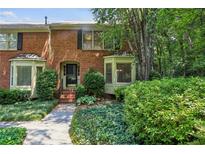 Charming brick townhouse with mature landscaping and bay windows for an inviting curb appeal at 1386 Sheffield Glen Ne Way, Atlanta, GA 30329