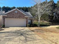 Charming brick home featuring a two-car garage and a patterned paver driveway at 1360 Raven Rock Nw Trl, Kennesaw, GA 30152
