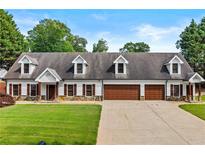 Charming home featuring a well-maintained lawn, a 3 car garage and classic dormer windows at 150 South St, Buford, GA 30518