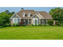 Charming brick home featuring manicured lawn and bay windows, offering classic curb appeal and a welcoming ambiance at 815 Spring View Ct, Covington, GA 30014