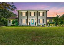 Elegant two-story brick home with a lush green lawn and a bright, inviting blue front door at 75 Auburn Rd, Auburn, GA 30011