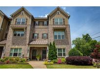 Charming brick townhome with a landscaped front yard, showcasing its inviting curb appeal and architectural details at 1365 Hawthorne Se Ave, Smyrna, GA 30080