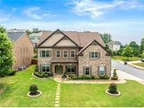 Beautiful two-story home featuring a well-manicured lawn and a classic brick facade with tasteful landscaping at 4015 Roberts Crest Ln, Suwanee, GA 30024