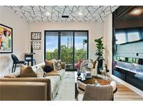Modern living room boasts a unique ceiling design, comfortable seating, and sliding glass doors to a balcony at 112 Rogers Street Ne # 505, Atlanta, GA 30317