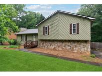 Charming home featuring a stone foundation and well-manicured lawn, creating a cozy curb appeal at 251 Sabrina Ct, Woodstock, GA 30188