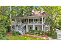 Charming two-story white home featuring double porches and lush green landscaping at 400 Old Ivy Ne Rd, Atlanta, GA 30342