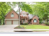 Charming two-story brick home featuring a three-car garage and a beautifully landscaped front yard at 5844 Brookstone Nw Walk, Acworth, GA 30101