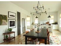 Open concept dining room with dark wood table, chandelier, and stylish decor adjacent to the modern kitchen at 2067 Telfair Circle # A&B, Atlanta, GA 30324