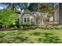 Charming cottage-style home with lush landscaping, inviting curb appeal, and a well-maintained front yard at 414 E Wesley Ne Rd, Atlanta, GA 30305