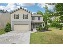 Inviting two-story home featuring a two-car garage, landscaped front yard, and covered entry way at 236 Arbor Creek Dr, Dallas, GA 30157