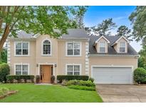 Charming two-story home featuring a manicured lawn, well-kept shrubbery, and an attached two-car garage at 3573 Willow Tree Trce, Decatur, GA 30034
