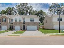 New construction townhomes with manicured lawns and brick and siding exteriors at 389 Navigator Ln, Mcdonough, GA 30253