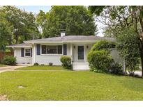 Charming home with manicured lawn, white painted brick, and blue shutters at 1060 Pinedale Se Dr, Smyrna, GA 30080