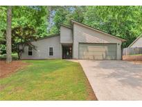 Charming single-story home with neutral siding, attached garage, and well-manicured lawn surrounded by mature trees at 2000 Kristian Way, Roswell, GA 30076