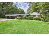 Charming single-story brick home with lush green lawn and attached carport at 1395 Clay Sw Rd, Mableton, GA 30126