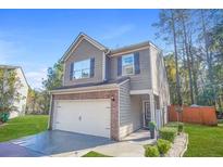 Charming two-story home featuring a brick facade and a two-car garage with an inviting front lawn at 3143 Bonnes Dr, Stonecrest, GA 30038