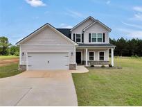 Charming two-story home with a two-car garage and well-manicured lawn at 715 Colvin Dr, Locust Grove, GA 30248