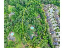 Stunning aerial view of a property with a private pool surrounded by lush greenery at 617 Rock Springs Rd, Lawrenceville, GA 30043