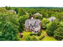 Back of house with deck overlooking manicured lawns and mature trees providing privacy at 5173 Brendlynn Dr, Suwanee, GA 30024