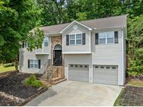 Charming two-story home with stone accents, gray siding, black shutters, and a two-car garage at 2623 Lone Oak Nw Trl, Kennesaw, GA 30144