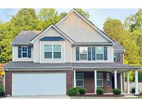 Charming two-story home featuring brick accents, a covered porch, and a well-maintained front yard at 5421 Skylar Creek Ln, Buford, GA 30518