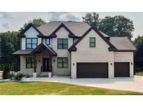 Charming two-story home with a brick facade, dark trim, a well-kept lawn, and an attached two-car garage at 1952 Azalea Dr, Lawrenceville, GA 30043