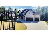 Gorgeous brick home with a black wrought iron fence and a well manicured lawn at 1952 Azalea Dr, Lawrenceville, GA 30043