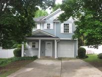 Charming two-story home featuring blue siding, a covered front porch, and an attached one-car garage at 215 Silver Spring St, Dallas, GA 30157