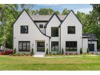 Stunning white modern farmhouse with black trim, beautiful landscaping, and a well manicured lawn at 4091 Oak Forest Drive Ne, Brookhaven, GA 30319