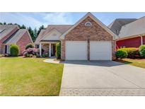 Charming brick home with attached two car garage and well-manicured lawn at 836 Windsor Place Ct, Grayson, GA 30017