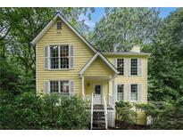 Charming yellow two-story home with white trim and mature landscaping at 1879 Beaver Dam Ne Ln, Marietta, GA 30062