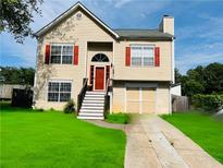 Charming two-story home features a well-maintained lawn, red shutters, and an attached garage at 5814 Highgrove Dr, Atlanta, GA 30349