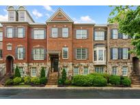 Beautiful brick townhome featuring stone accents, shutters, and manicured landscaping at 1227 Parkside Village Nw Dr, Marietta, GA 30060