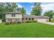 Charming brick and siding home with a well-manicured lawn, attached garage, and attractive landscaping at 3947 Veracruz Ct, Decatur, GA 30034