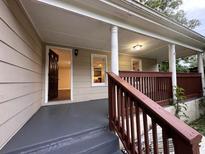 Inviting front porch with painted floors, white columns, and a dark stained railing at 1095 S Burnt Hickory Rd, Douglasville, GA 30134