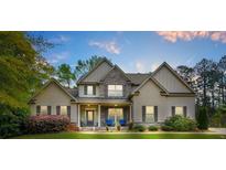 Charming two-story home with a well-manicured lawn, stone accents, and inviting front porch with blue chairs at 229 Primstone Way, Mcdonough, GA 30253