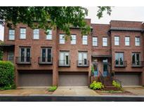 Beautiful brick townhome with a two-car garage and small wrought iron balconies at 440 Canton Walk, Roswell, GA 30075