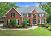 Traditional two-story brick home with manicured lawn and mature landscaping creates great curb appeal at 9595 Rod Rd, Alpharetta, GA 30022