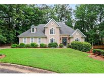 Charming home exterior with a well-maintained lawn and lush greenery at 4990 Sawgrass Nw Pl, Acworth, GA 30102