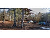 Property showing a house situated on an expansive lot with mature trees, with multiple cars parked outside at 594 Collinsworth Rd, Palmetto, GA 30268