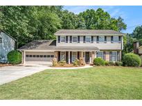 Charming two-story home with a manicured lawn and a two-car garage nestled among lush greenery at 1703 W Nancy Creek Ne Dr, Brookhaven, GA 30319
