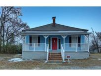 Charming single story home featuring a quaint front porch, red door, and blue siding at 1730 Spring Ne St, Conyers, GA 30012