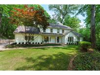 Charming two-story home featuring a well-manicured lawn and a classic painted brick facade at 4219 Harrogate Nw Dr, Atlanta, GA 30327